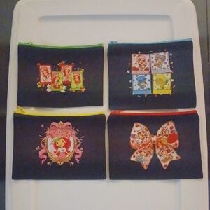 Set of Four Black Pouches with Colorful Strwberry Shrtcakes Designs